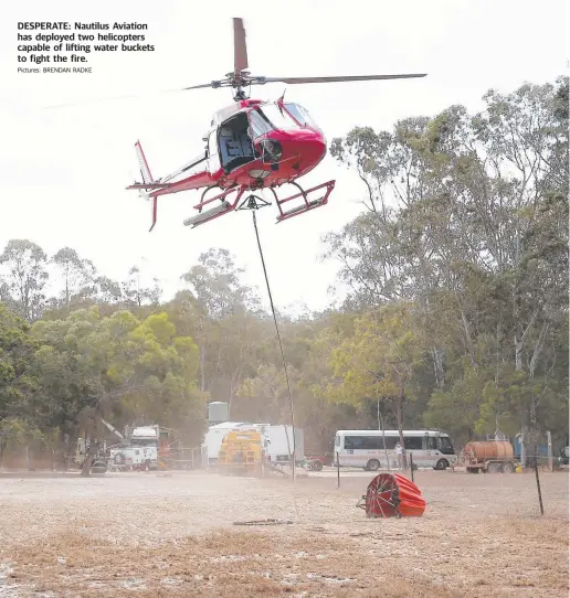  ?? Pictures: BRENDAN RADKE ?? DESPERATE: Nautilus Aviation has deployed two helicopter­s capable of lifting water buckets to fight the fire.