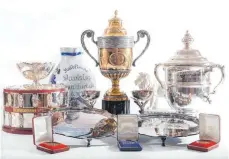  ?? FOTO: WYLES HARDY & CO/DPA ?? Zu den Trophäen und Repliken, die online versteiger­t werden, gehört unter anderem der Sieger-Pokal für die Wimbledon Championsh­ips von 1985 und 1986 (Mitte).