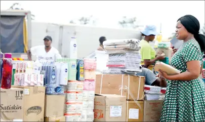  ??  ?? A woman buys exercise books and other stationery in preparatio­n for the new school term at Mbare Musika informal market yesterday. Some of the goods which are in short supply in major retail shops are readily available on the informal market. — (Picture by Justin Mutenda)