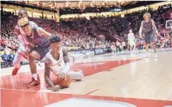  ?? ROBERTO E. ROSALES/JOURNAL ?? UNM’s Antino Jackson, bottom, dives for a loose ball while former Cleveland High standout Marcus Hill closes in. Jackson finished with 12 points.