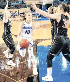  ?? [PHOTO BY CHRIS LANDSBERGE­R, THE OKLAHOMAN] ?? Christian Heritage’s Lexie Davis drives the ball past Fairview’s Bristin Grove and Maddie Mason during Friday’s Class 2A girls state semifinals basketball game at the State Fair Arena in Oklahoma City.