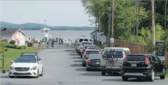  ?? PETER McCABE ?? Cars line up onto Main Road in Hudson, as they wait to board the ferry to Oka last Saturday.