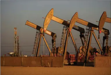  ?? (Eli Hartman/ Odessa American via AP) ?? An array of pumpjacks operate near the site of a new oil and gas well being drilled earlier this month in Midland, Texas.