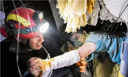  ?? — aFP ?? Easy does it: a firefighte­r trying to rescue a man stuck in the ruins of a collapsed building in Thumane, northwest of capital Tirana.