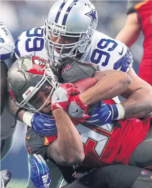  ?? TOM PENNINGTON GETTY IMAGES ?? Antwaun Woods of the Dallas Cowboys tackles Jacquizz Rodgers of the Tampa Bay Buccaneers Sunday in Arlington, Texas. Dallas has captured three division titles in five years.