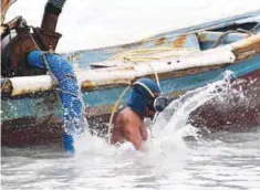  ??  ?? A file picture showing Paci diving into the waters to dredge for tin off Sungai Liat in northeast Bangka.