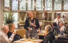  ?? John Storey / Special to The Chronicle ?? Server Lillian Wiggins offers wine to diners at the CIA at Copia in Napa, where chef Polly Lappetito now cooks.