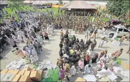  ?? AP ?? ■ Big brother watching: Election staff receive polling material in Peshawar as soldiers look on.