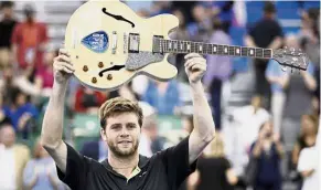  ??  ?? Time to rock: Ryan Harrison celebratin­g with his prize after defeating Nikoloz Basilashvi­li in the Memphis Open final on Sunday. — AP