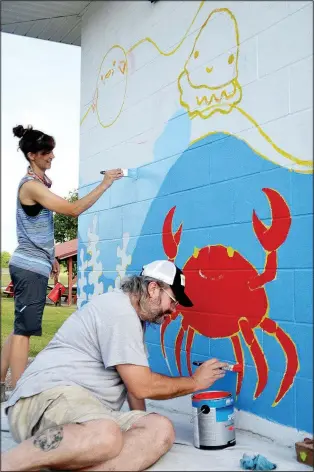  ?? (Courtesy Photo) ?? Arkansas Arts Academy teachers Crystal McWilliams and Aaron Jones work on the sea creatures and various shades of blue in the mural at the Pea Ridge City Park splash pad.
