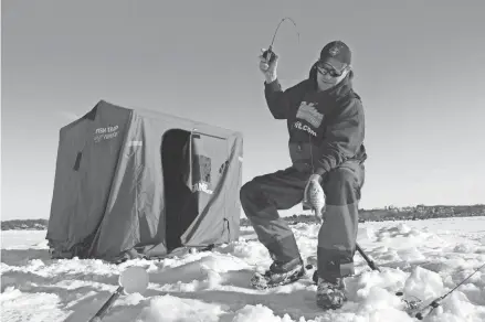  ?? PAUL A. SMITH ?? Brian Settele of Menomonee Falls lands a bluegill while ice fishing on Pewaukee Lake.