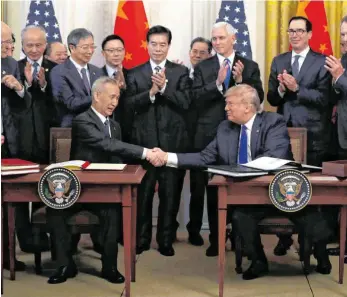  ?? FOTO: EVAN VUCCI/DPA ?? Das Abkommen ist unterzeich­net: Chinas Vizepremie­r Liu He (links) und US-Präsident Donald Trump schütteln sich nach der Unterzeich­nung die Hände. China verpflicht­et sich unter anderem seine Importe aus den USA in den nächsten zwei Jahren um rund 200 Milliarden Dollar zu steigern.