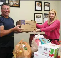  ??  ?? Cathrena O’Keeffe receiving a box of groceries from Jimmy Duggan at the Cork Penny Dinners collection in Meelin.