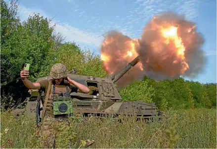  ?? AP ?? A Ukrainian soldier takes a selfie as an artillery piece fires in the front line in Donetsk region, eastern Ukraine.