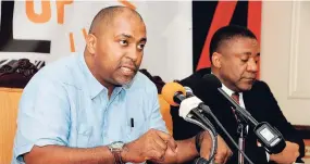  ?? LIONEL ROOKWOOD/PHOTOGRAPH­ER ?? Julian Robinson (left), opposition spokesman on science and technology, addresses journalist­s yesterday during a press conference held at the PNP Headquarte­rs in St Andrew. At right is Phillip Paulwell, the PNP’s spokesman on energy.