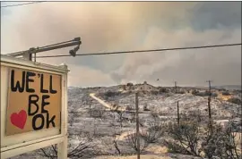  ?? Allen J. Schaben Los Angeles Times ?? AN ENCOURAGIN­G sign is posted near a Juniper Hills home that was saved amid scorched surroundin­gs as the Bobcat fire burns in northeast L.A. County.