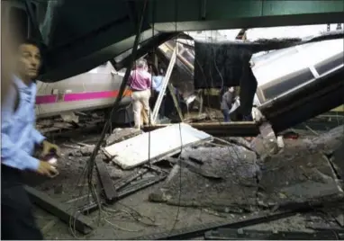  ?? WILLIAM SUN VIA THE ASSOCIATED PRESS ?? People examine the wreckage of a New Jersey Transit commuter train that crashed into the train station during the morning rush hour Thursday in Hoboken, N.J.