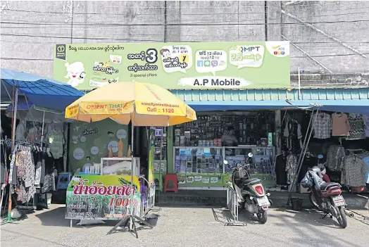  ??  ?? CALL HOME: A Burmese-language sign promotes mobile telephone services in downtown Phuket. Many young Myanmar migrants intend to return home as soon as they have earned enough on the southern resort island.