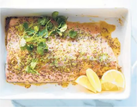  ?? CHRISTOPHE­R SIMPSON/THE NEW YORK TIMES ?? Baked maple salmon is ready in less than half an hour and served simply with lemon wedges.