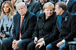  ?? FRANCOIS MORI/GETTY-AFP ?? French President Emmanuel Macron and German Chancellor Angela Merkel sit with President Donald Trump and first lady Melania Trump on Sunday at the Arc de Triomphe in Paris.
