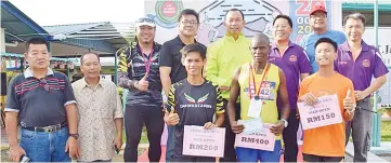  ??  ?? Winners of the Men’s Open category take one for the album with organisers, officials and guests of honour at the SEMESJA Run in Tenghilan on Sunday.