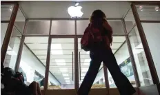  ??  ?? WASHINGTON, DISTRICT OF COLUMBIA: This file photo taken on September 16, 2016 shows a woman walking past Batu Adamis from Turkey, sleeping outside the Apple store to buy the new a Apple iPhone 7. — AP