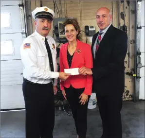  ?? Ernest A. Brown photo ?? Woonsocket Fire Chief Paul Shatraw, Mayor Lisa Baldelli-Hunt and Woonsocket Public Safety Director Eugene Jalette, from left, accept a check at fire department headquarte­rs in the amount of $2,000.00 as a donation from the Wat Lao Buddhist Temple’s board of directors during a ceremony on Wednesday.