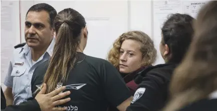  ?? (Hadas Parush/Flash90) ?? AHED TAMIMI (center) is brought to the Ofer Military Court yesterday, following an incident on Friday in which she and her cousin confronted two soldiers near her home in the West Bank village of Nabi Saleh.