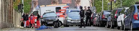  ?? FOTO: REUTERS ?? Polizei und Rettungskr­äfte am Tatort vor der Synagoge und dem jüdischen Friedhof in Halle. Unter der Plane liegt ein Opfer