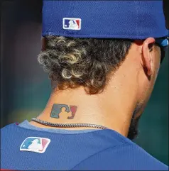  ?? PABLO MARTINEZ MONSIVAIS/AP 2017 ?? Former Cubs infielder Javier Baez sports three MLB logos — his tattoo and logos on his hat and jersey — as he waits to take batting practice before a playoff game against the Nationals in 2017. Baez agreed to a $140 million, six-year deal with the Tigers this week.