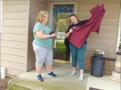  ?? ZACHARY SRNIS — THE MORNING JOURNAL ?? Laura Below, a senior at Avon Lake High School, and her mother, Linda Below, take out her cap and gown for photos.