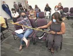  ??  ?? Angela Tate, right, and Annette Quinata, owner of Covenant Care Assisted Living, make sure they are properly socially distanced at the meeting.