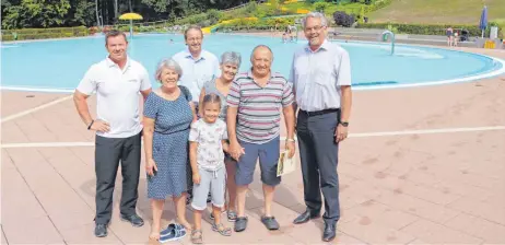  ?? FOTOS: STEPPAT ?? Maik Uliczek (links), Kultur- und Sportamtsl­eiter Hermann Spang (hinten, Mitte) und Bürgermeis­ter Ulrich Mauch (rechts) begrüßten mit Peter Böhm (Zweiter von rechts) den 100 000. Gast im Freibad. Mit ihm freuen sich (von links) Olga Weber, Mia und Tamara Böhm.