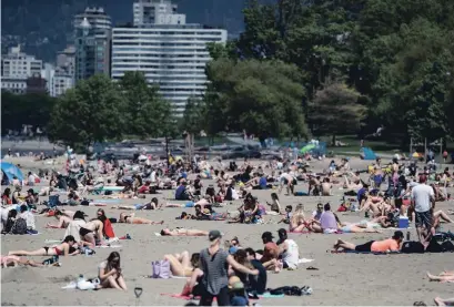  ?? DARRYL DYCK THE CANADIAN PRESS ?? People sun themselves at Kitsilano Beach in Vancouver on Saturday, as temperatur­es reached into the 20s.