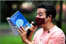  ?? AP PHOTO/MARCO UGARTE ?? Percibald Garcia uses a microphone to read aloud children’s books amid the high-rise housing complex of Tlatelolco, in Mexico City, Saturday.