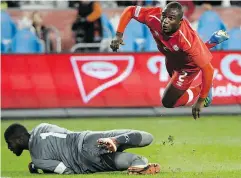  ?? NATHAN DENETTE / THE CANADIAN PRESS ?? Zachary Brault-Guillard goes airborne as Dominica keeper Glenson Prince makes the save during CONCACAF qualifying soccer action in Toronto on Tuesday.