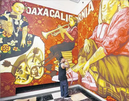  ?? Al Seib Los Angeles Times ?? ARTIST DARIO CANUL from the Tlacolulok­os artist collective in Oaxaca, Mexico, puts finishing touches on murals in the Los Angeles Central Library’s rotunda.