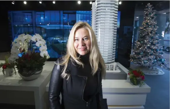  ?? J.P. MOCZULSKI FOR THE TORONTO STAR ?? Milena Eglite, a Latvian-born florist, stands in front of the model for the Minto Yorkville Park building, where she bought two condos, one for her and one for her parents.