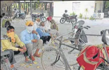  ?? RAVI KUMAR/HT ?? Labourers waiting for contractor­s near the Sector 44/45/50/51 roundabout in Chandigarh.