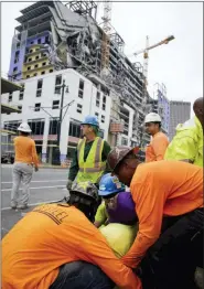  ?? SCOTT THRELKELD—ASSOCIATED PRESS ?? Workers are helped after a large portion of a hotel under constructi­on suddenly collapsed in New Orleans on Saturday, Oct. 12, 2019.