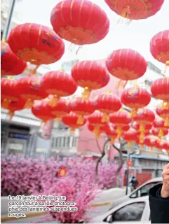  ??  ?? Le 19 janvier à Beijing, un garçon tout à sa joie photograph­ie des lanternes suspendues rouges.