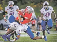  ?? JIM WEBER/NEW MEXICAN FILE PHOTO ?? Lobos receiver Luke Wysong, center, is taken down after a reception during a Sept. 2 game against Houston Baptist at University Stadium. The Lobos will face San Diego State on Saturday in Carson, Calif.