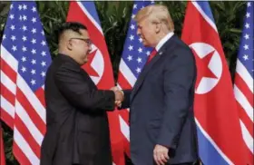  ?? EVAN VUCCI — THE ASSOCIATED PRESS ?? U.S. President Donald Trump shakes hands with North Korea leader Kim Jong Un at the Capella resort on Sentosa Island on Tuesday in Singapore.