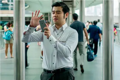  ??  ?? A man uses his phone to play the Pokemon Go app in the Central district of Hong Kong. —