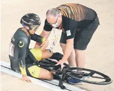  ?? — AFP photos ?? Azizulhasn­i is assisted a er falling before competing in a heat of the men’s track cycling sprint 1/8 finals.