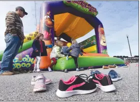  ?? (NWA Democrat-Gazette/Flip Putthoff) ?? Kids leave their shoes on the walk to play Saturday in a bounce house at the 8th Street Gateway Park community input event in Bentonvill­e. Go to nwaonline.com/200209Dail­y/ to see more photos.