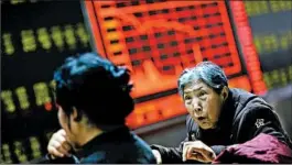  ?? HOW HWEE YOUNG/EPA ?? Investors in Beijing monitor trading as Chinese exchanges caused a global sell-off Monday.