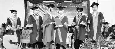  ?? ?? TAHNIAH: Snowdan (tiga kanan) menyampaik­an sijil kepada salah seorang graduan sambil diperhatik­an yang lain.