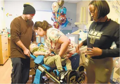  ?? BARBARA HADDOCK TAYLOR/BALTIMORE SUN ?? Camdyn Carr, 4, is being treated at Kennedy Krieger Institute for acute flaccid myelitis, a rare, polio-like condition. He is getting physical therapy from Courtney Porter, center, while rehab technician Kia Barlow, right, and his father, Christophe­r Carr, watch.