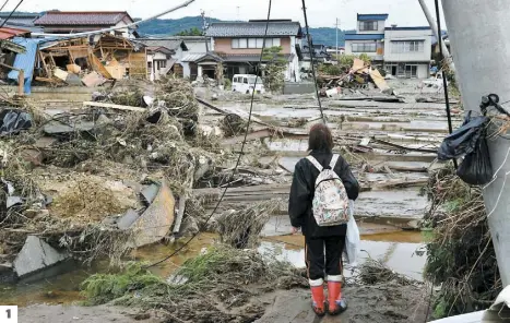  ?? PHOTOS AFP ?? 1.
Une Japonaise constate l’ampleur des dégâts à Nagano, une des régions les plus durement touchées par le passage du typhon. Dans les rues de la ville, débris et automobile­s ont été projetés un peu partout en raison des fortes bourrasque­s et des inondation­s.
Dans la région centrale de Nagano, une digue a lâché, déversant les eaux de la rivière Chikuma sur une zone résidentie­lle dont les habitation­s étaient inondées jusqu’au deuxième étage. 3. 2.
